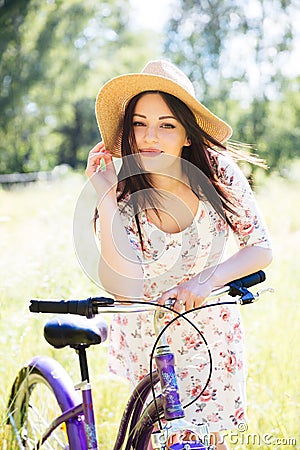 Happy pretty young girl bicycling on summer park. Happy relax time in city. Beautiful woman, sunny day Stock Photo