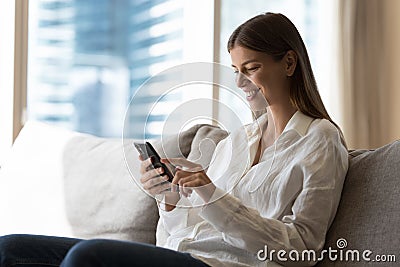 Happy pretty young smartphone user woman typing text message Stock Photo