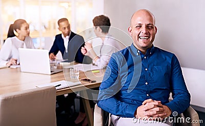 Happy and proud businessman representing his team sitting behind him Stock Photo