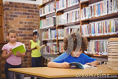 Happy pupil reading a library book Stock Photo