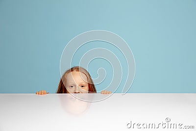 Happy redhair girl isolated on blue studio background. Looks happy, cheerful, sincere. Copyspace. Childhood, education Stock Photo