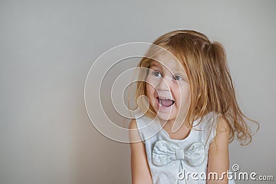 Happy redhair girl in white dress on light gray background Stock Photo