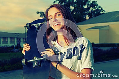 Happy redhair teen girl posing with skateboard Stock Photo