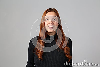 Happy redhead girl on gray background Stock Photo