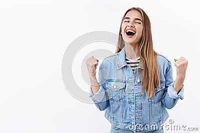 Happy and relieved young free girl feel empowered and joyful, fist pump scream yes from happiness, triumphing clench Stock Photo