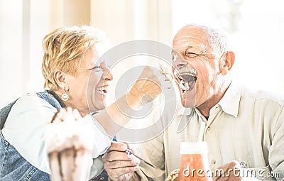 Happy retired senior couple in love enjoying bio icecream cup Stock Photo