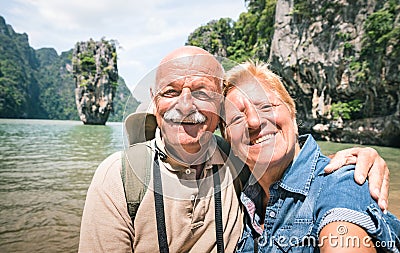 Happy retired senior couple taking travel selfie around world - Stock Photo