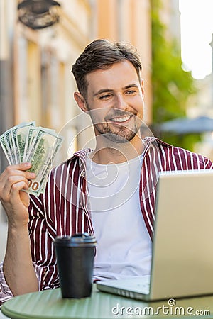 Happy rich man counting money dollar cash menu app ordering food, delivery online in city cafeteria Stock Photo