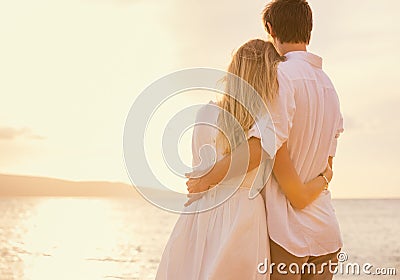 Happy romantic couple on the beach at sunset Stock Photo