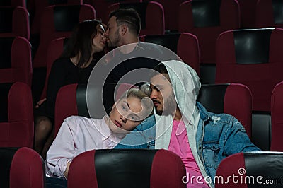 Happy romantic couples in movie theater Stock Photo