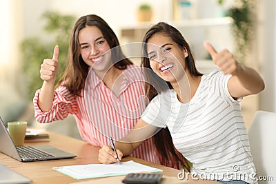 Happy roommates signing form with thumbs up Stock Photo