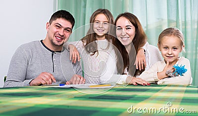 parents with little children buying insurance and smiling Stock Photo