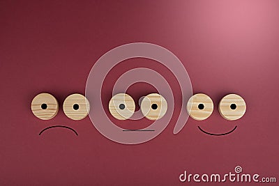 Happy and sad smiles on a wood circles on wood on a red Stock Photo