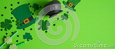 Happy Saint Patrick`s day banner mockup. Shamrock and four leaf clovers, Irish elf hats, pot of gold and drinking straw on green Stock Photo