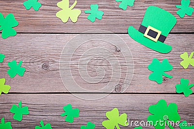 Happy Saint Patrick`s of handmade paper clover leaves and hat on grey wooden background Stock Photo