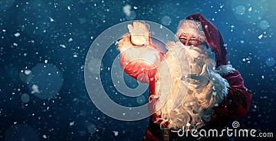 Happy Santa Claus holding glowing christmas ball Stock Photo