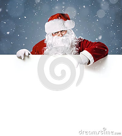 Happy Santa Claus pointing on blank white advertisement banner Stock Photo