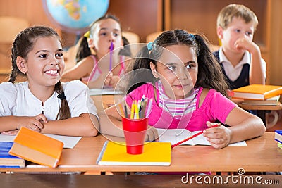 Happy schoolchildren during lesson in classroom Stock Photo