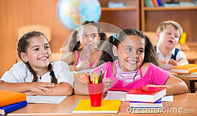 Happy schoolchildren during lesson in classroom Stock Photo