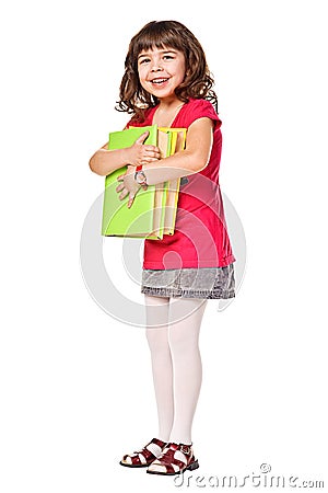 Happy schoolgirl holding pile of books Stock Photo