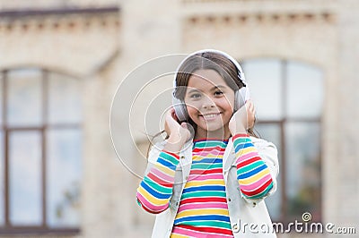 Happy schoolgirl in stylish hipster outfit. childhood happiness. kid in digital earphones. small student girl listen Stock Photo
