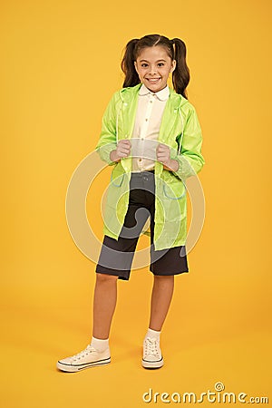 Happy schoolgirl wear raincoat. Invest in durable kids rainwear to keep children out in fresh air. Waterproof concept Stock Photo