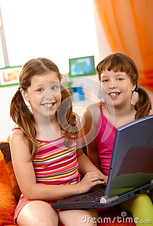 Happy schoolgirls with laptop Stock Photo