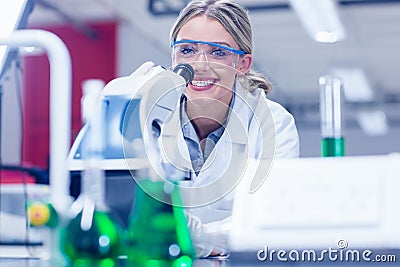 Happy science student working with microscope in the lab Stock Photo