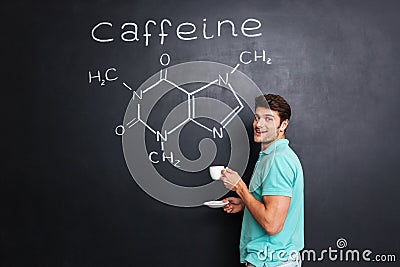 Happy scientist drinking coffee over chemical structure of caffeine molecule Stock Photo