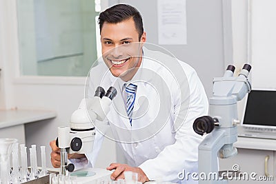 Happy scientist using microscope Stock Photo