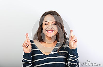 Happy screwing up eyes beautiful woman crossing her fingers, hoping, asking the wish Stock Photo