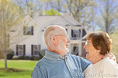 Happy Senior Couple in Front Yard of House Stock Photo