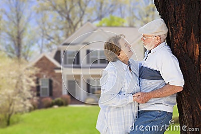 Happy Senior Couple in Front Yard of House Stock Photo