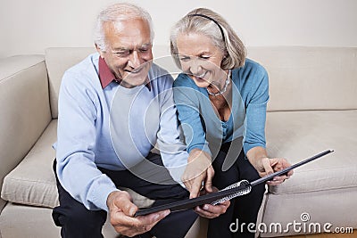 Happy senior couple looking at spiral book Stock Photo