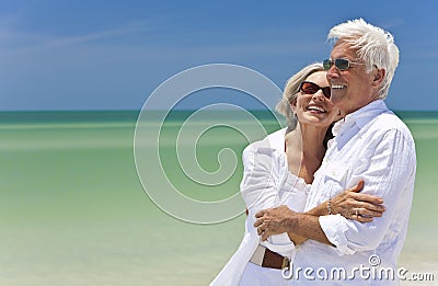 Happy Senior Couple Looking To Sea on Beach Stock Photo