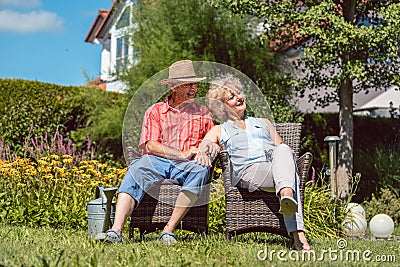 Happy senior couple in love relaxing together in the garden in a Stock Photo