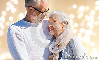 Happy senior couple over festive lights background Stock Photo