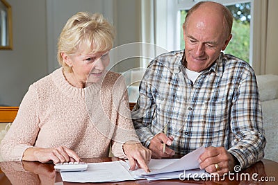 Happy Senior Couple Reviewing Domestic Finances Together Stock Photo