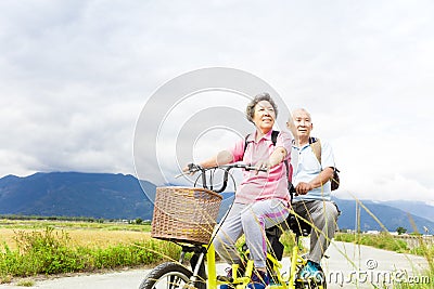 Happy Senior Couple Riding Bicycle on country road Stock Photo