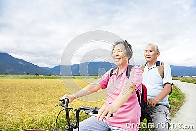 Happy Senior Couple Riding Bicycle on country road Stock Photo