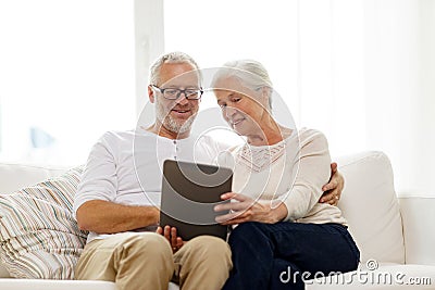 Happy senior couple with tablet pc at home Stock Photo