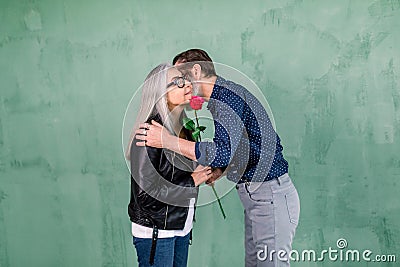 Happy senior family portrait. Handsome elderly bearded man giving beautiful red fresh rose to his charming smiling wife Stock Photo