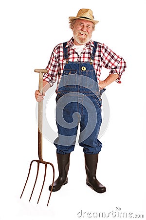 Happy senior farmer holding hay fork Stock Photo