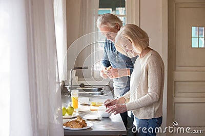 Happy senior couple make healthy breakfast on home kitchen Stock Photo