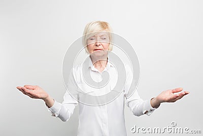 Happy senior lady meditating. She is searching for calm and trying to find herself. She wants to be hapy in her old age Stock Photo