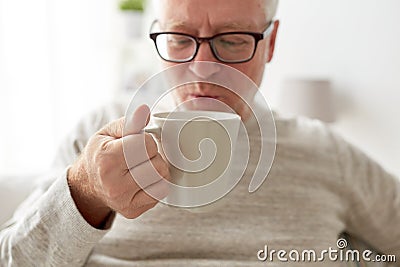 Happy senior man drinking tea or coffee at home Stock Photo