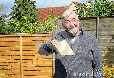 Happy senior man giving a plain brown envelope. Stock Photo