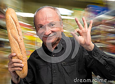 Happy senior man holding fresh baguette Stock Photo