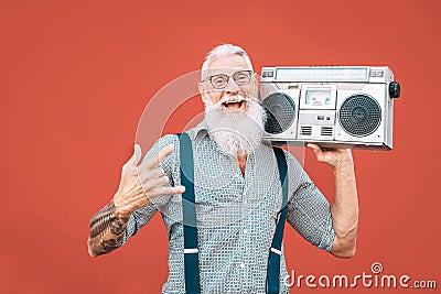 Happy senior man listening to music with boombox outdoor - Crazy hipster male having fun dancing with vintage stereo Stock Photo
