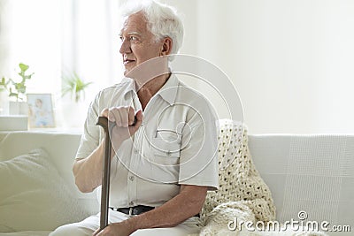 Happy senior man with walking stick relaxing in a nursing house Stock Photo